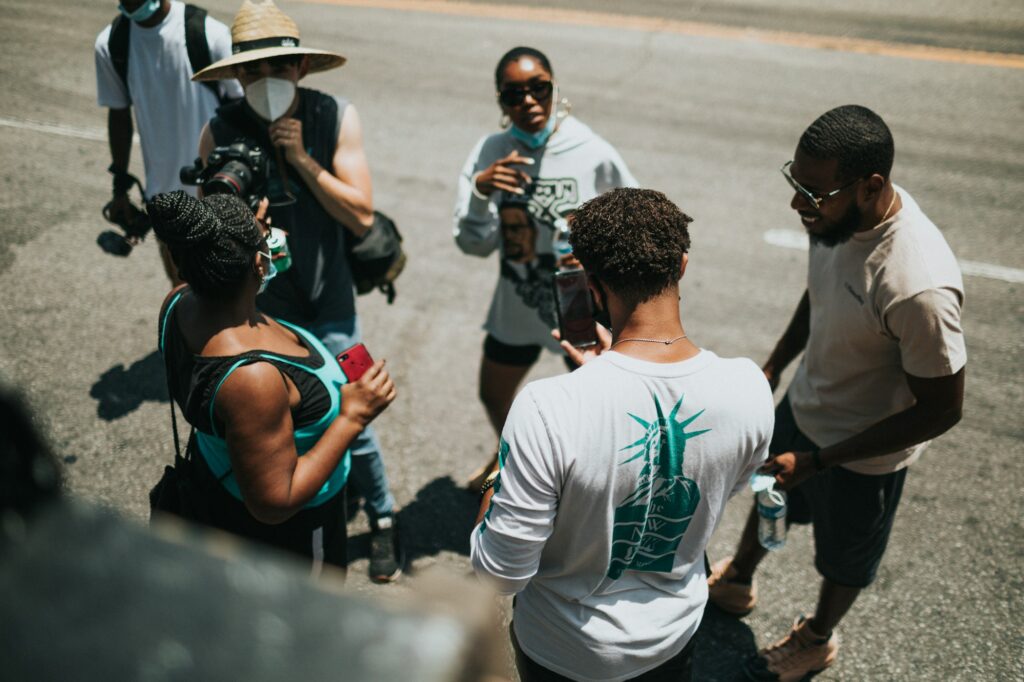 Young filmmakers gathered around a camera during a street shoot