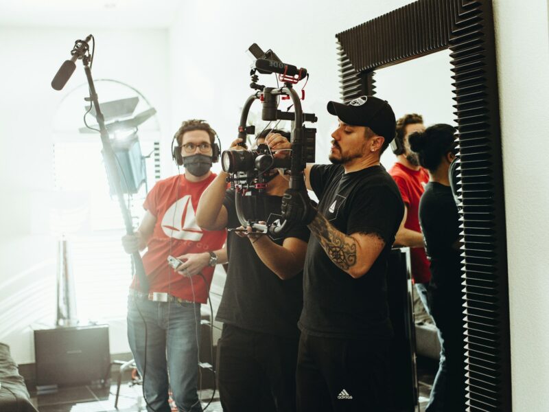 A small film crew with a camera and boom mic on set