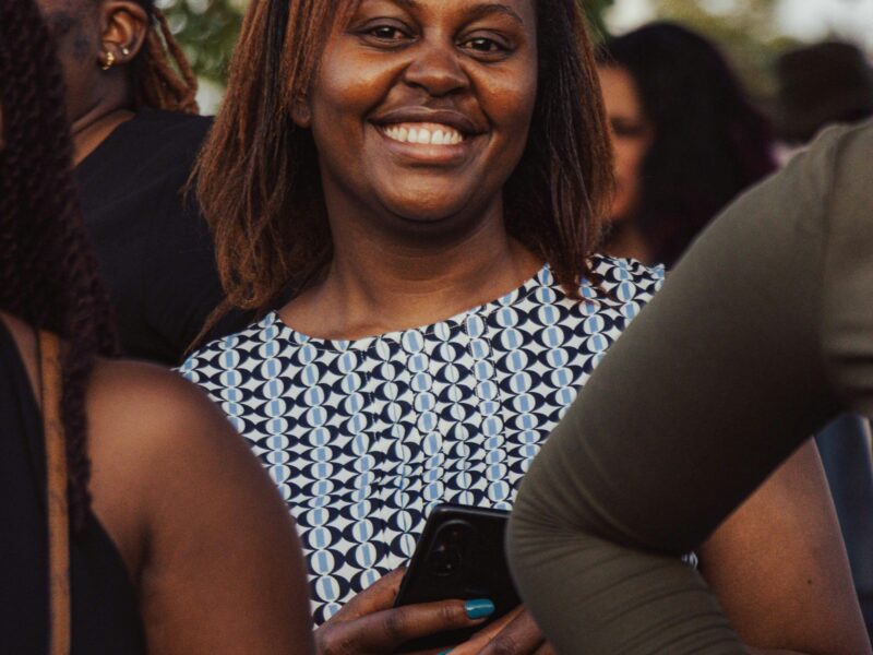 A smiling young woman in a crowd at a community event